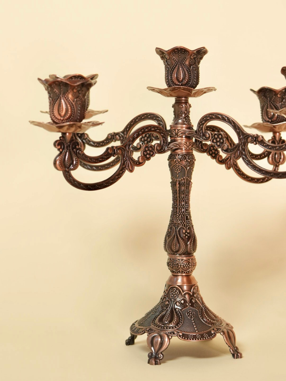 Decorative bronze candelabra on a beige background