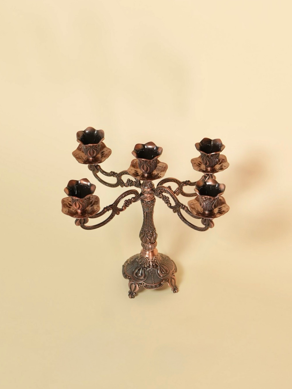 Decorative bronze candelabra on a beige background