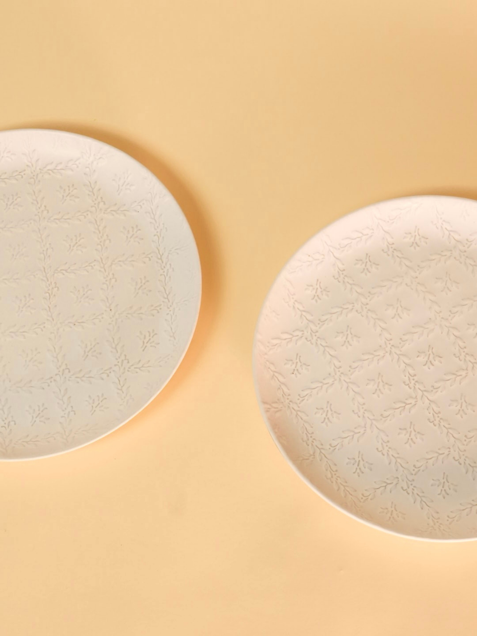Two round, textured cream-colored objects on a beige background