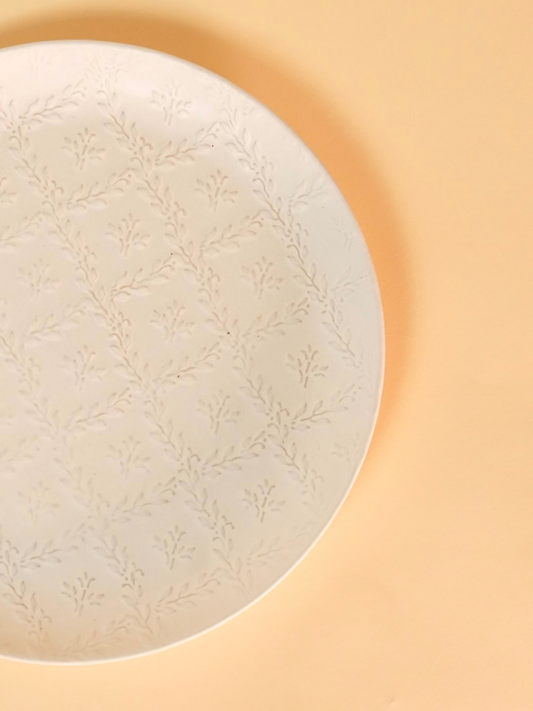 Round light fixture with embossed design on a beige background