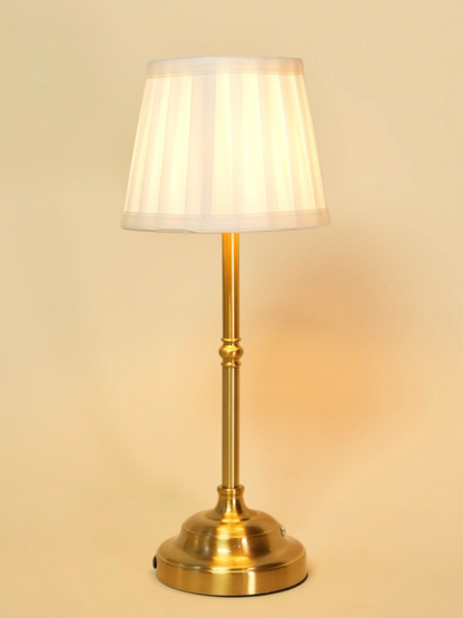 Brass floor lamp with a white shade on a beige background