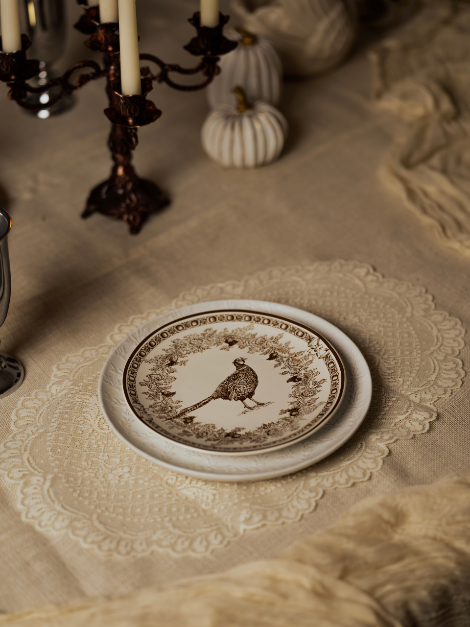 Decorative plate with a bird design on a tablecloth with lace edge