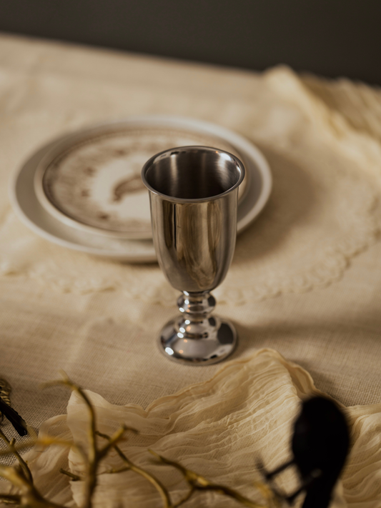 Silver goblet on a textured surface with a neutral background