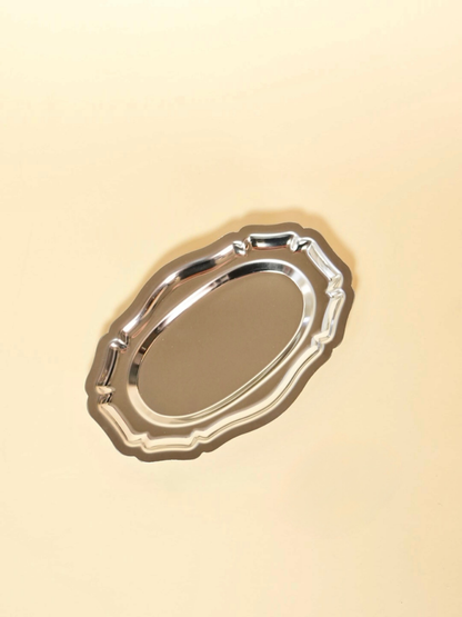 Silver oval tray on a beige background