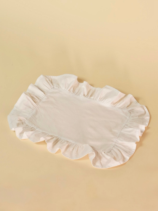 White ruffled placemat on a beige background