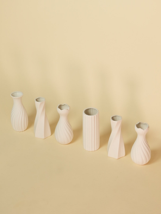 Set of six beige ceramic vases on a beige background